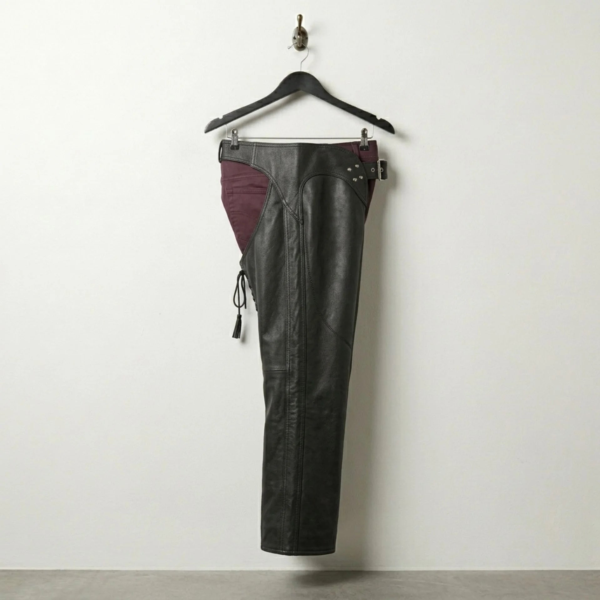 Side profile of men's black leather chaps showing full-length leg coverage