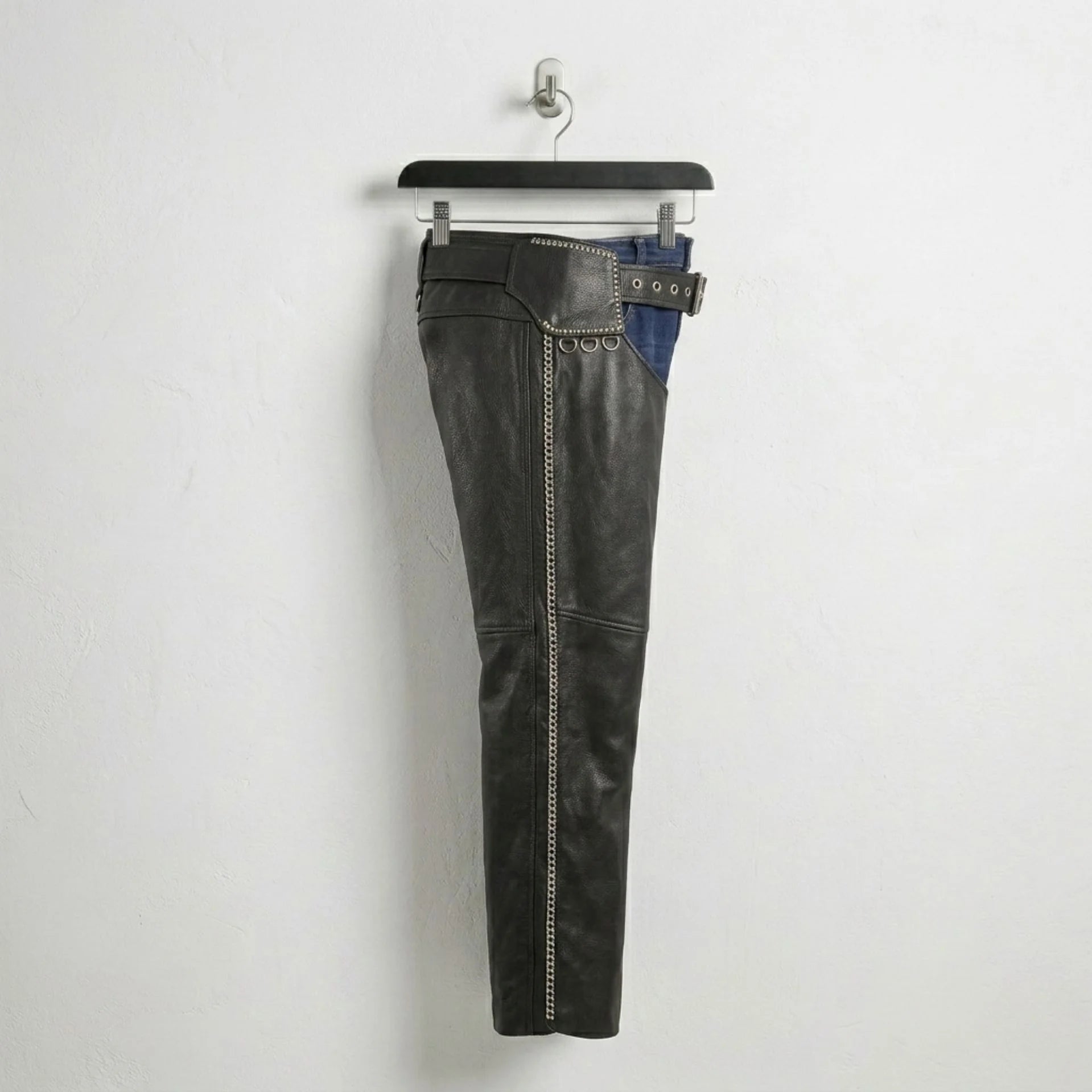 Side profile of men's black leather chaps with full-length zipper and studs.