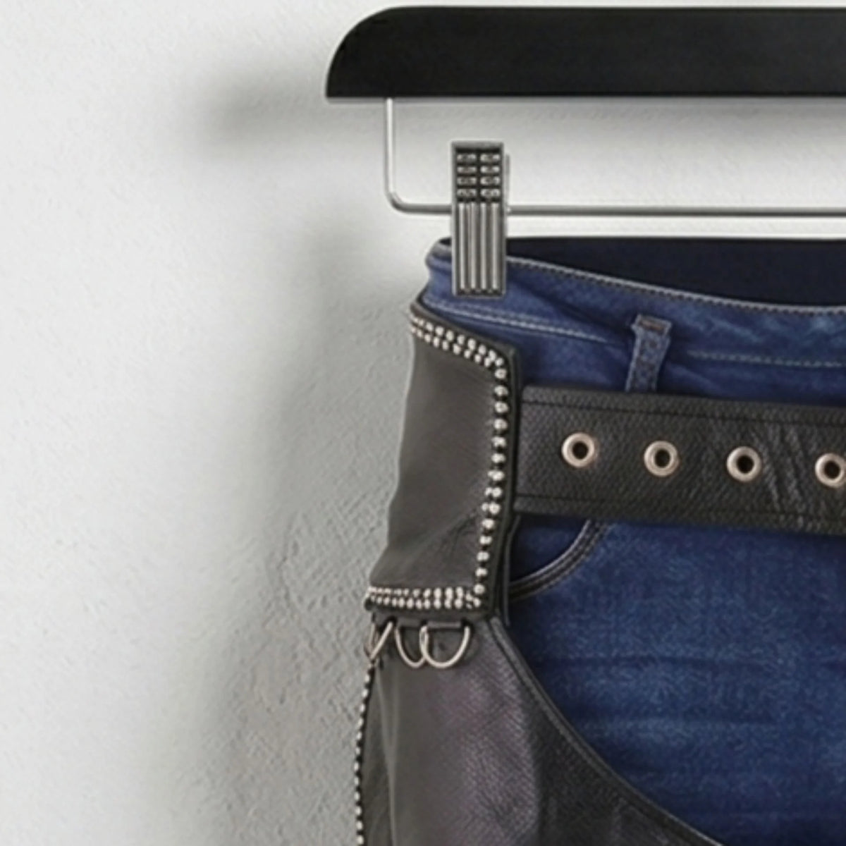 Close-up of studded hip panel and grommet belt on men's black leather chaps