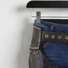 Close-up of studded hip panel and grommet belt on men's black leather chaps