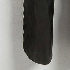 Detail of lower leg and side zipper on genuine black leather chaps