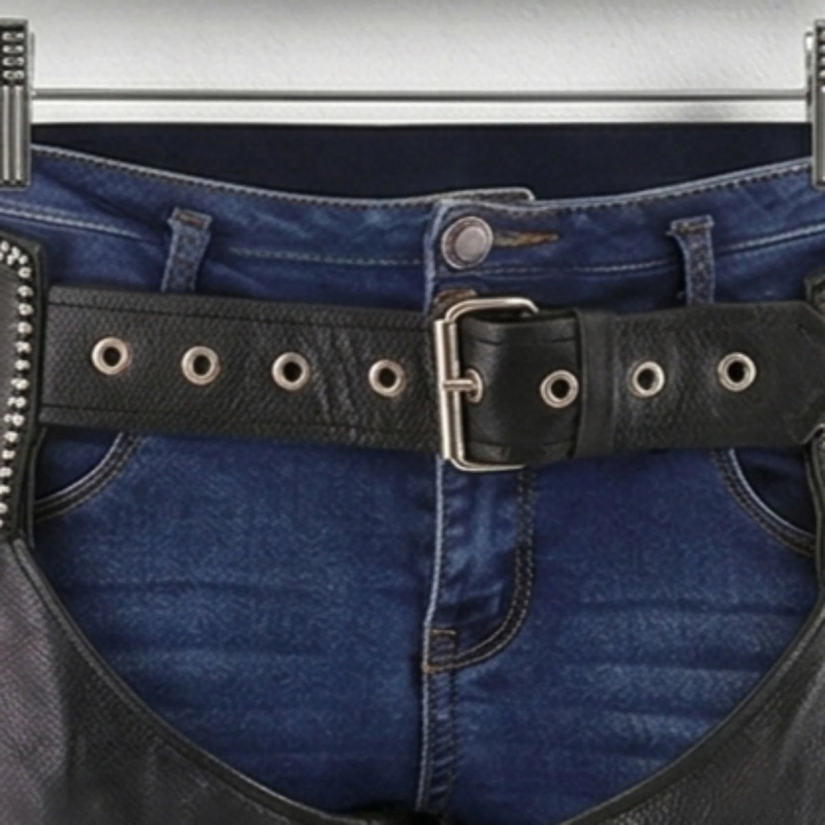 Close-up of adjustable grommet belt and buckle on men's motorcycle chaps