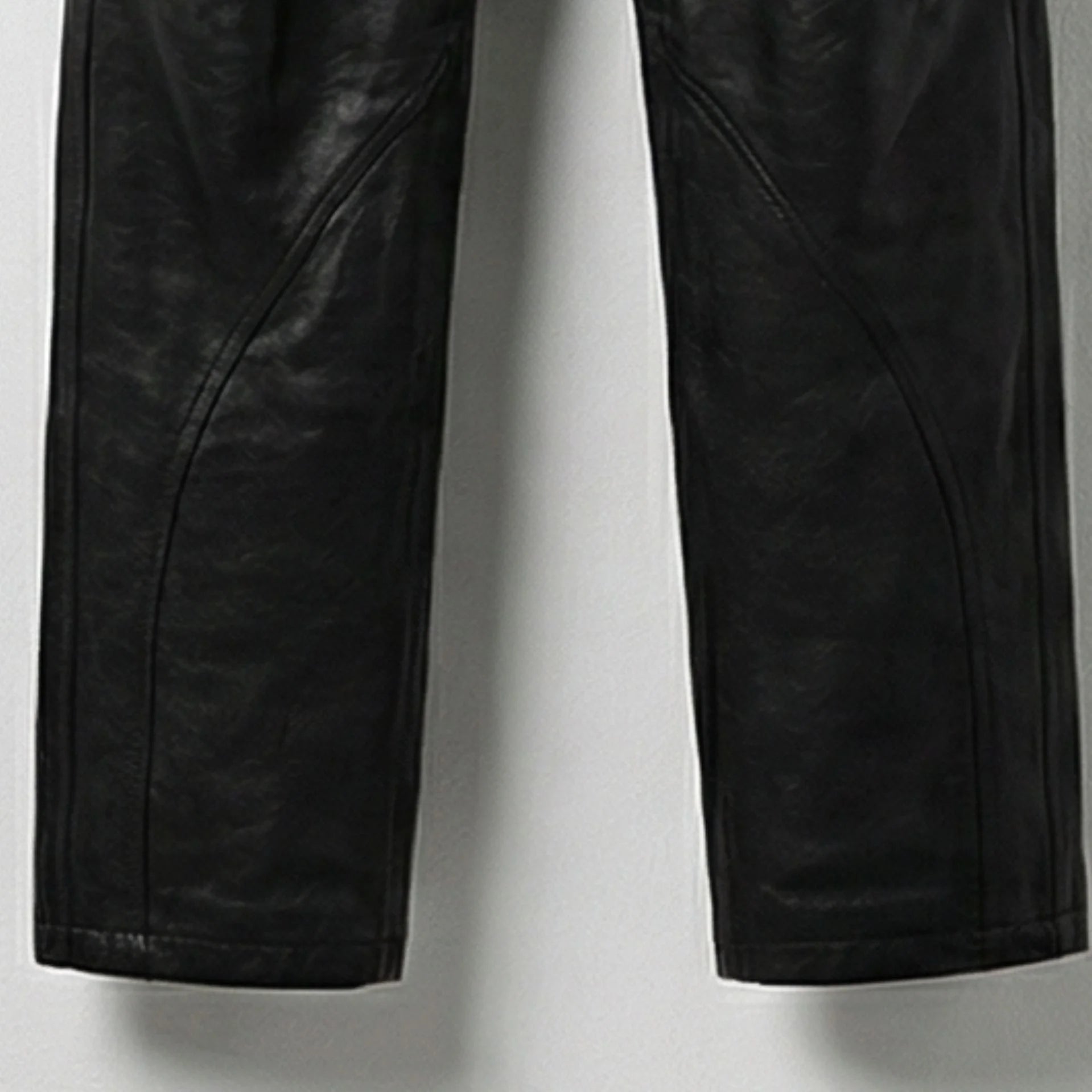 Detail of lower legs and seam design on men's black leather overalls