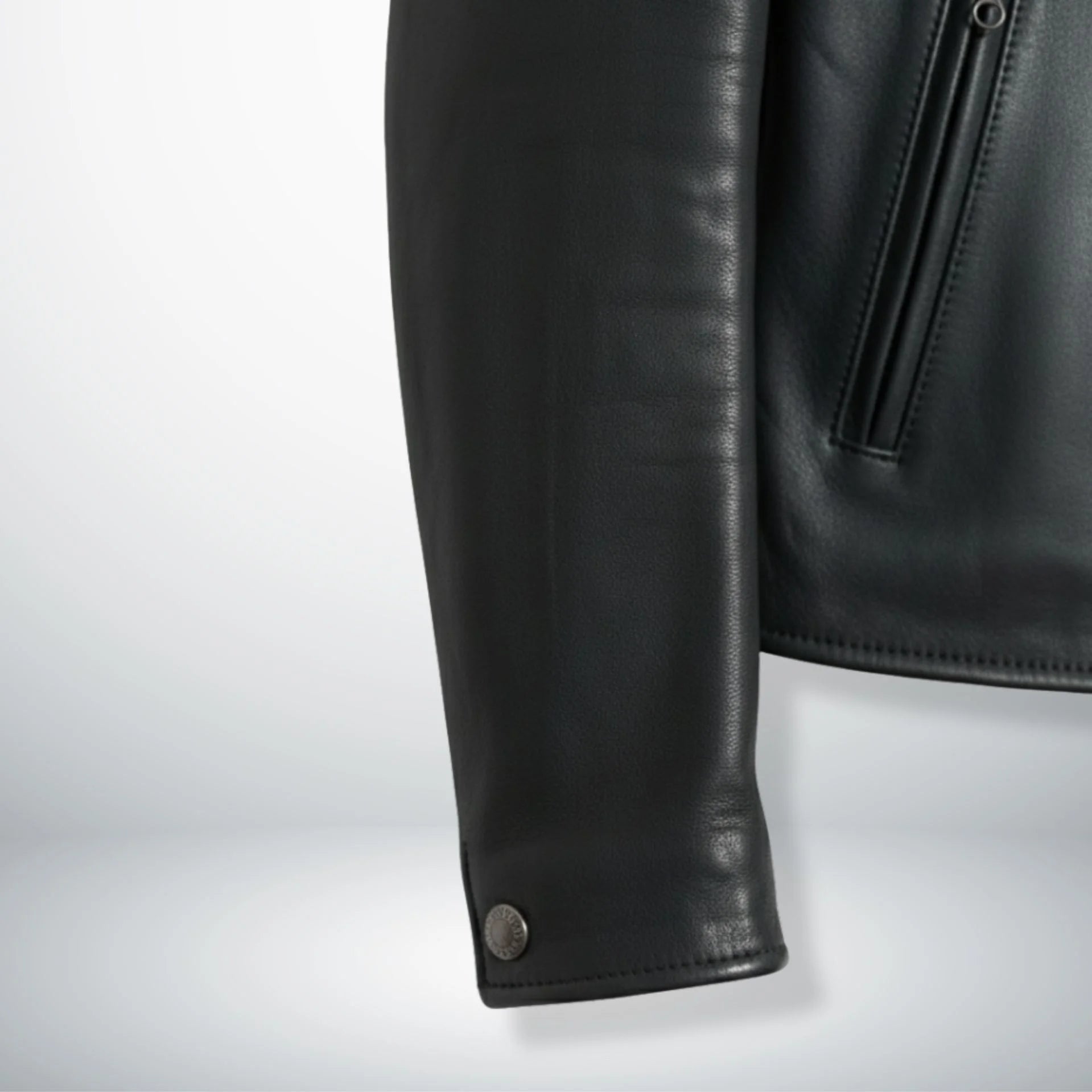 close up of sleeve and snap cuff on men's black leather rider jacket.