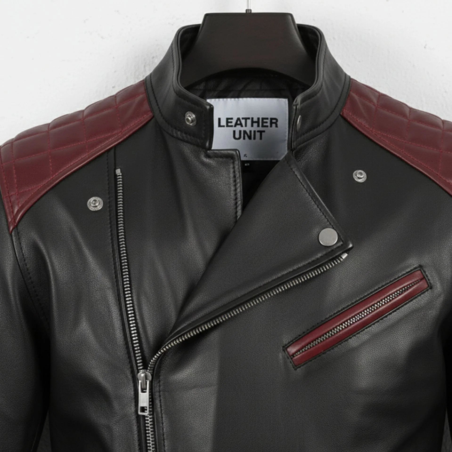 close up of collar and chest pocket on men's black and maroon biker leather jacket.