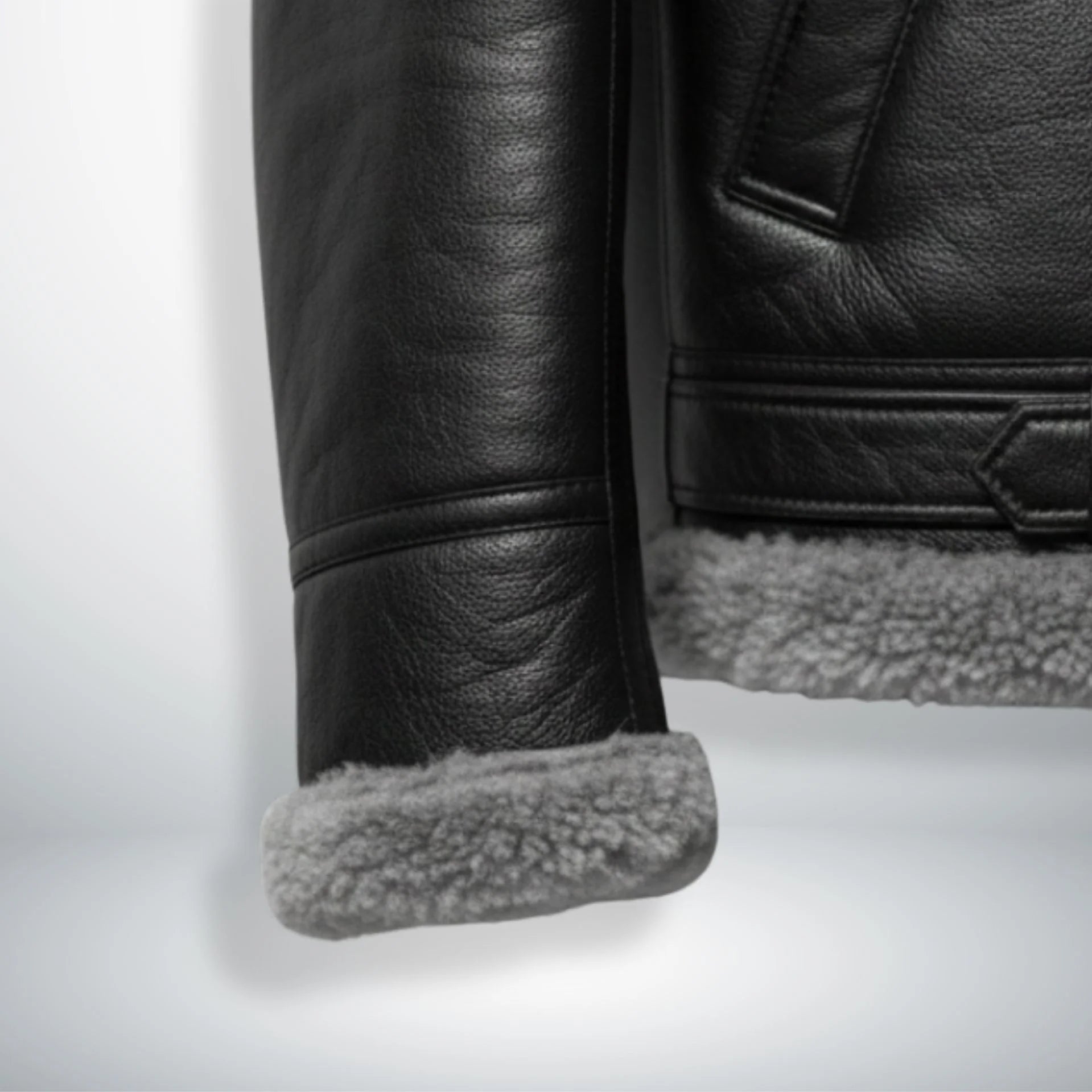 close up shearling cuff and hem on mens black aviator leather jacket.