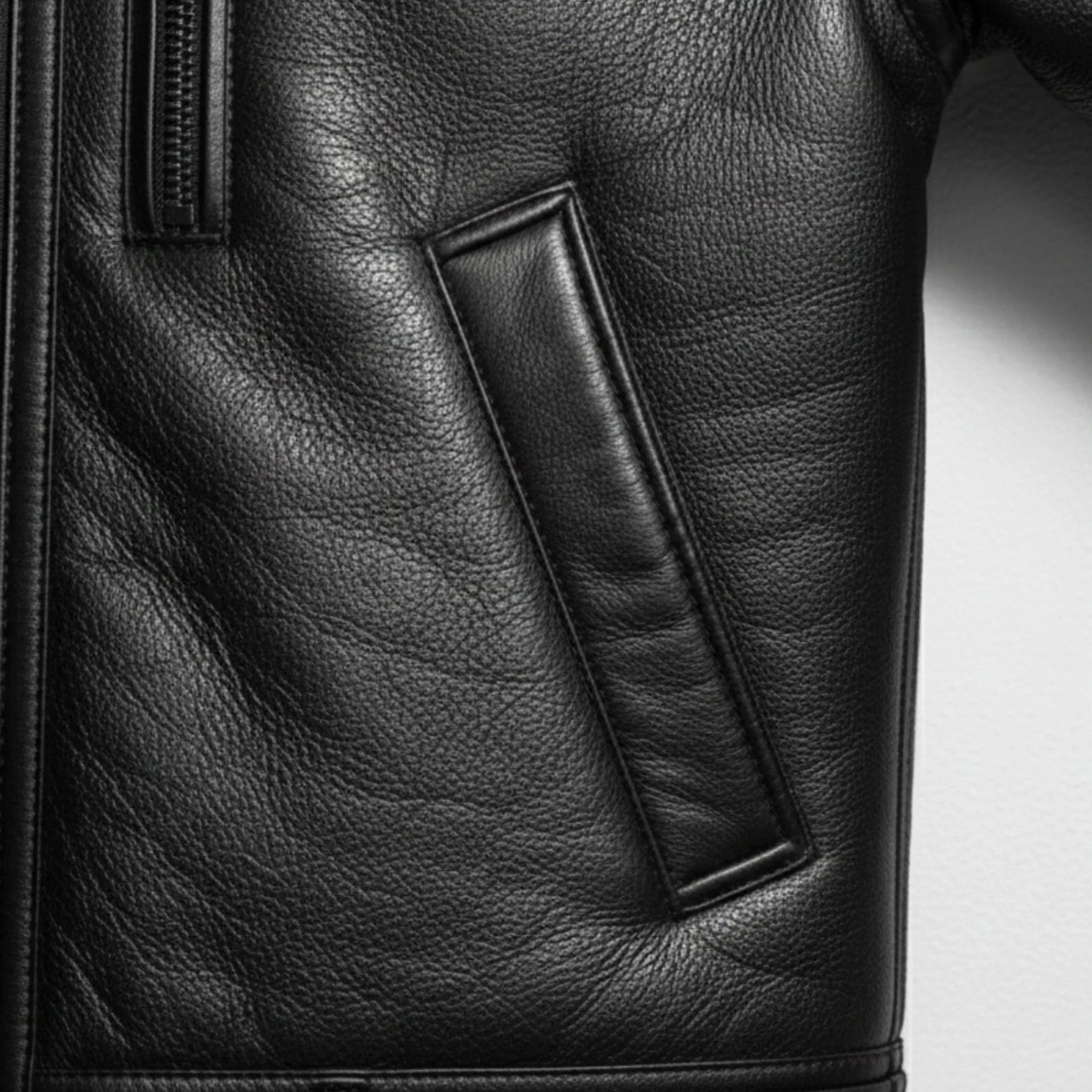 close up welt hand pocket on mens black shearling leather jacket.