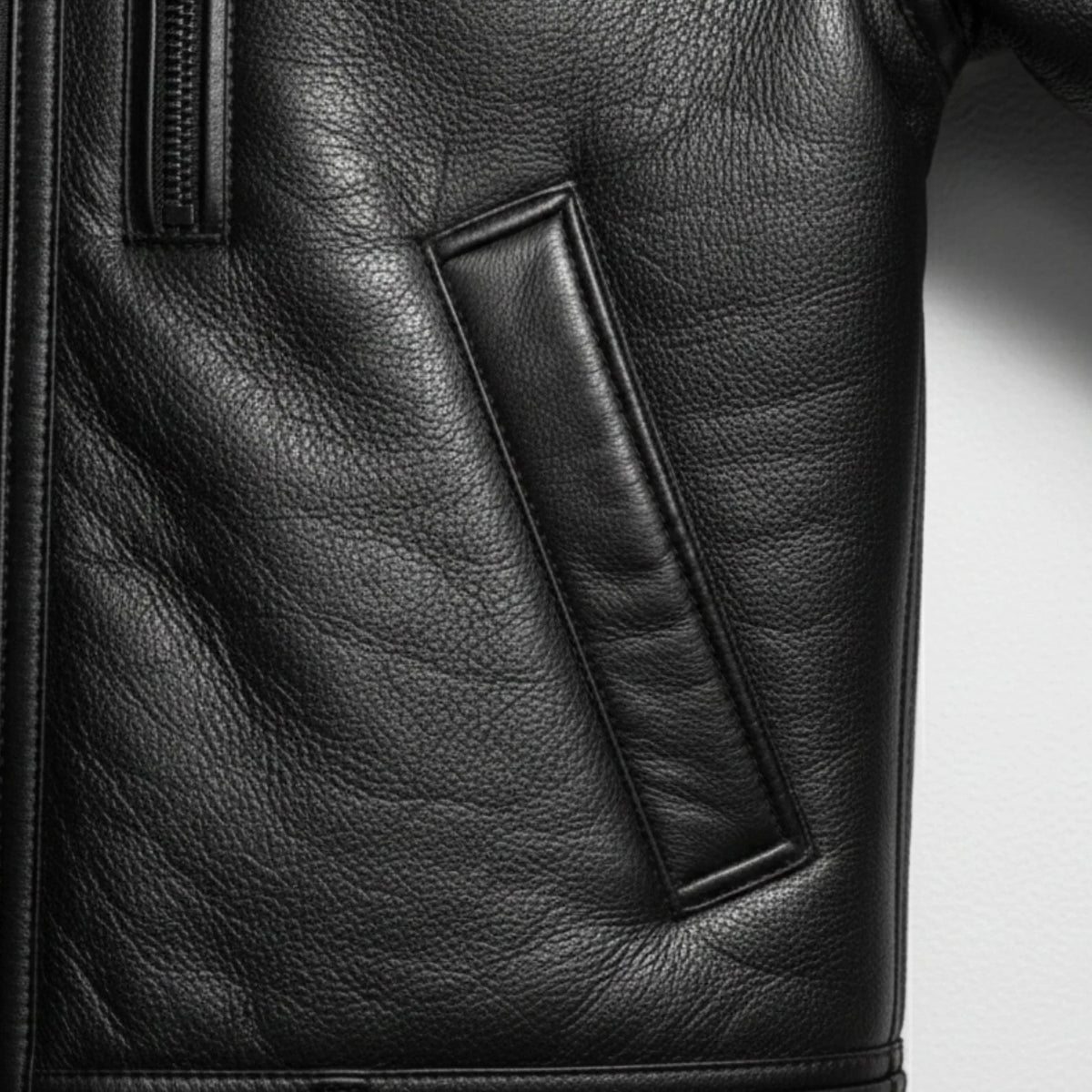 close up welt hand pocket on mens black shearling leather jacket.