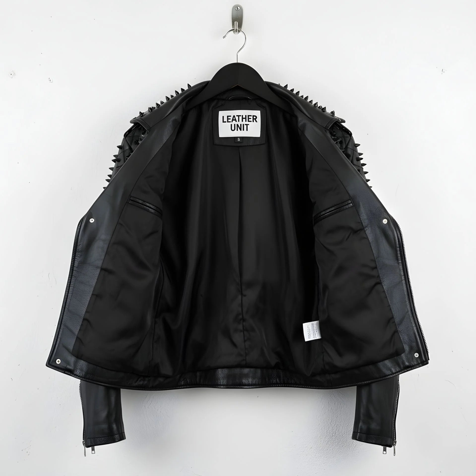interior of men's black studded biker jacket showing smooth black lining and inner pocket.