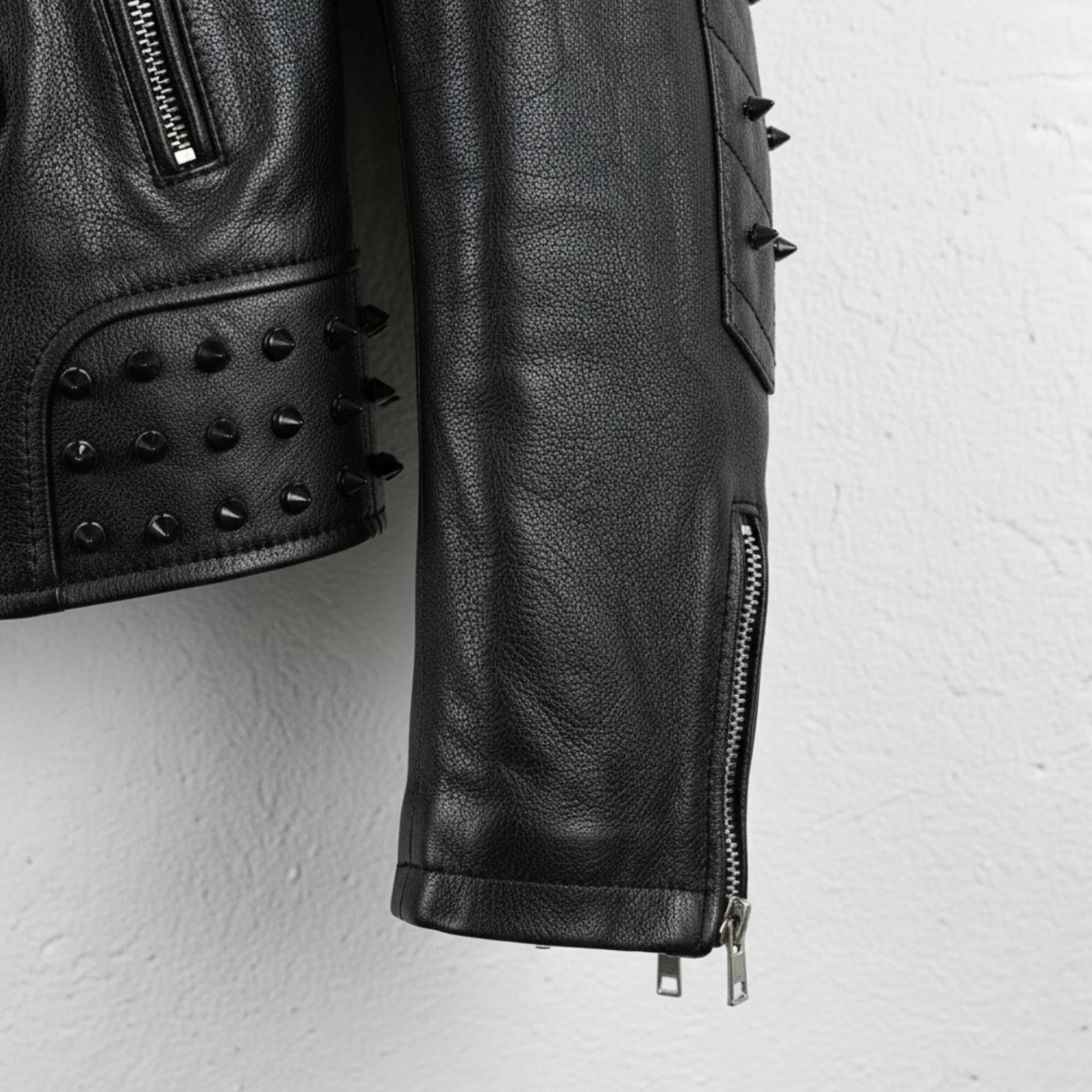 sleeve and cuff zipper detail with studs on men's black spike moto jacket.