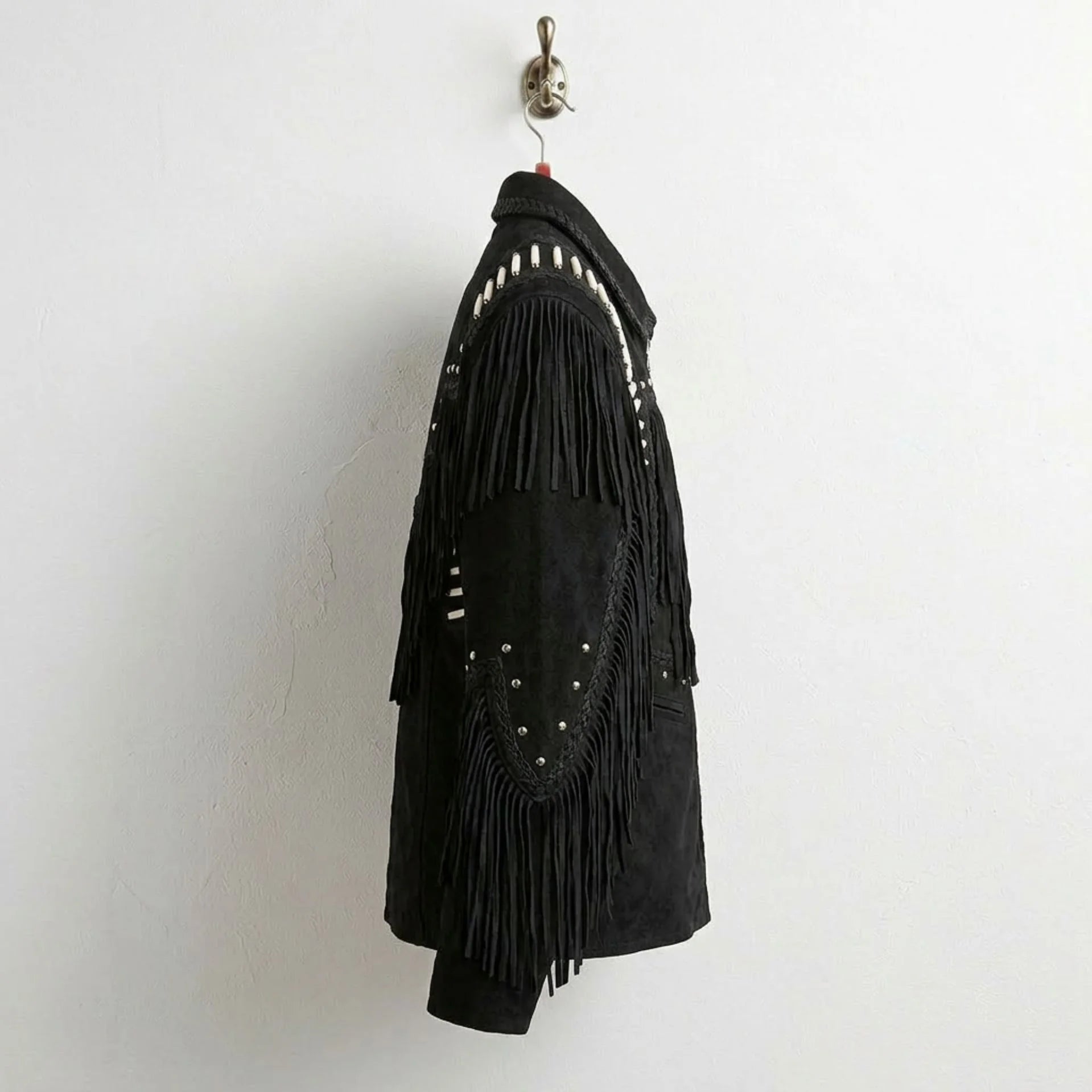 Side profile of men's black suede western jacket with sleeve fringe and bone trim.