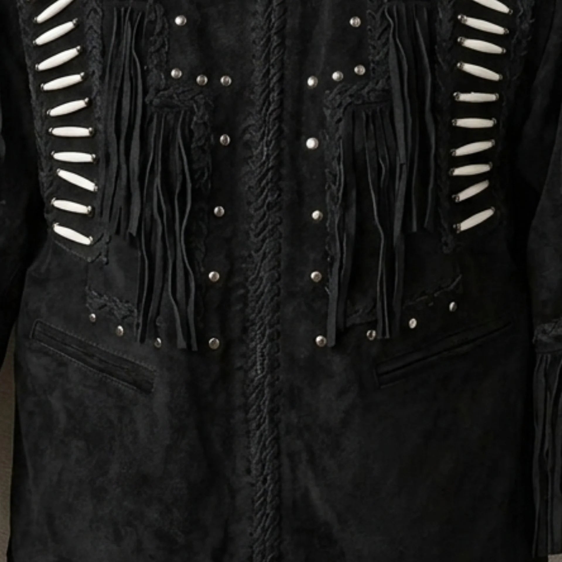 Close up of front bone and stud detailing on men's black suede fringe jacket.