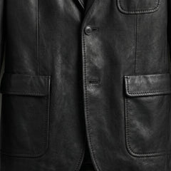 Patch pockets and button close up on men’s black leather blazer