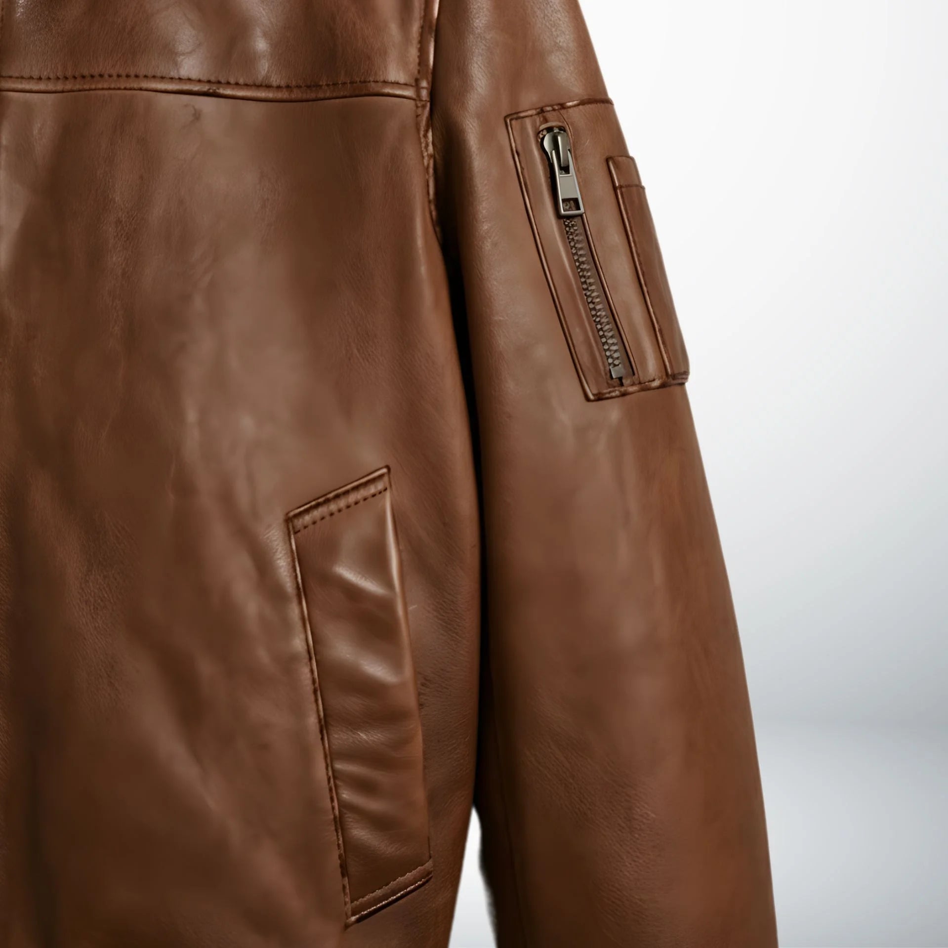 model wearing men's brown bomber leather jacket with jeans.