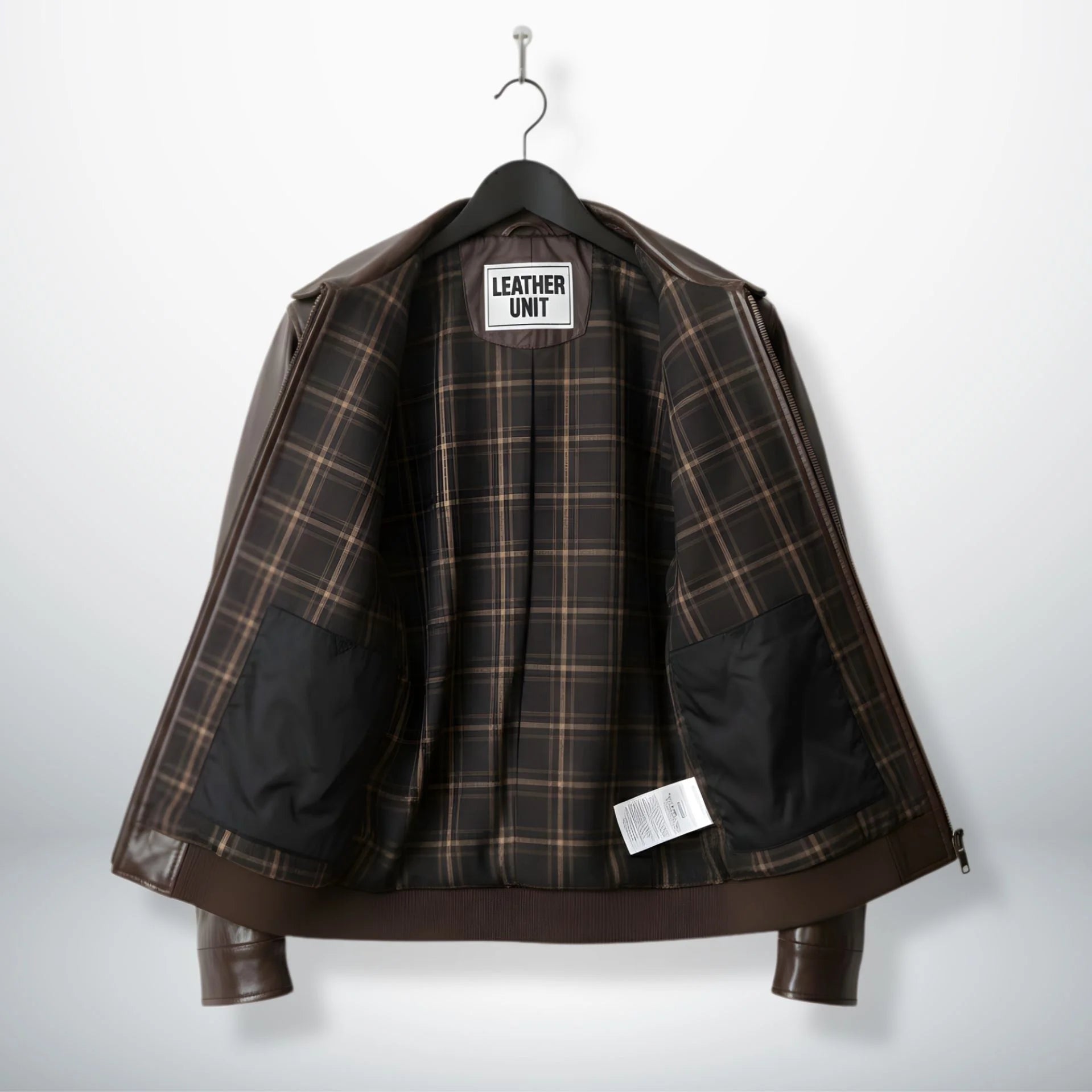 inside view brown bomber leather jacket with plaid lining and interior pockets.