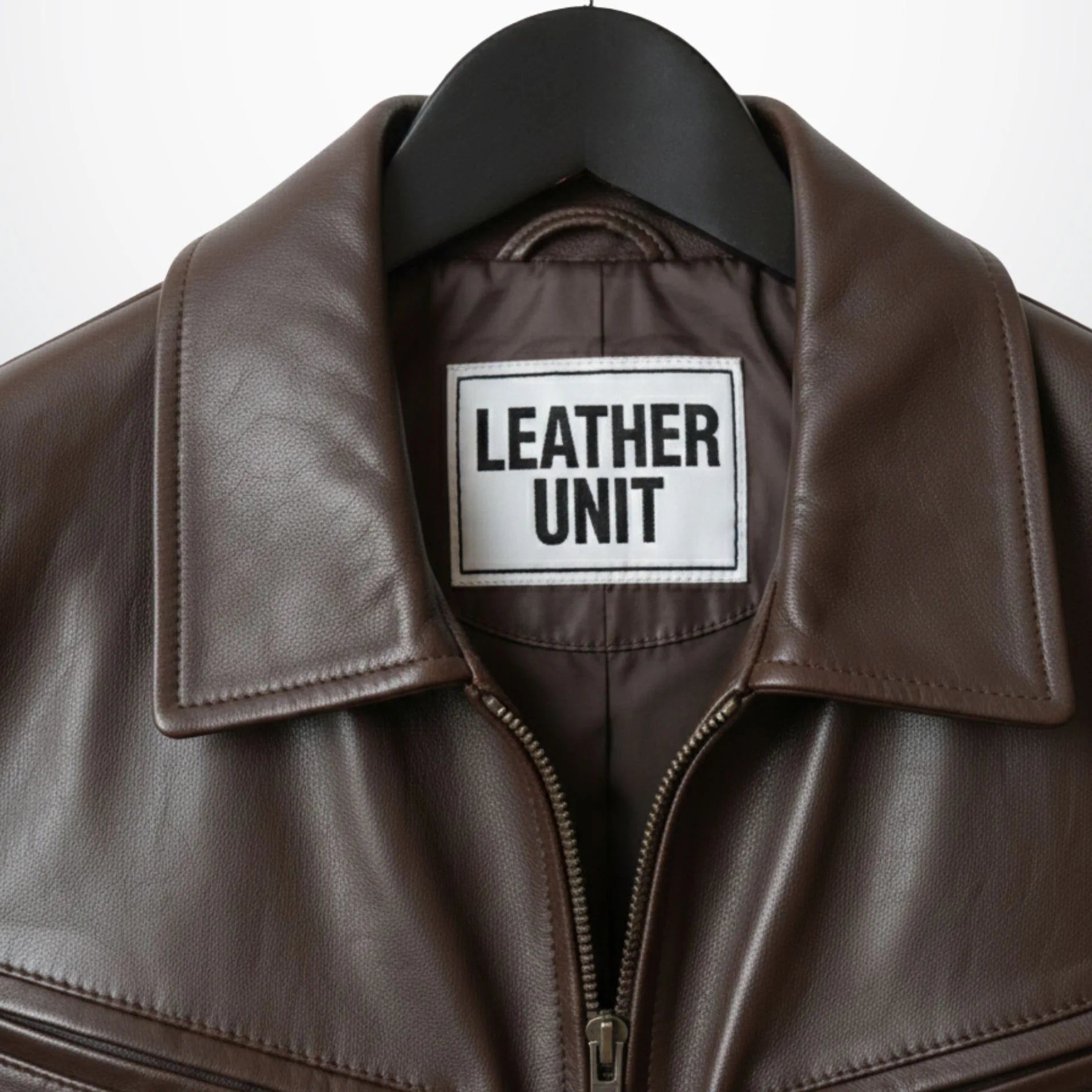 close up collar and zipper on mens brown bomber leather jacket leather unit label.