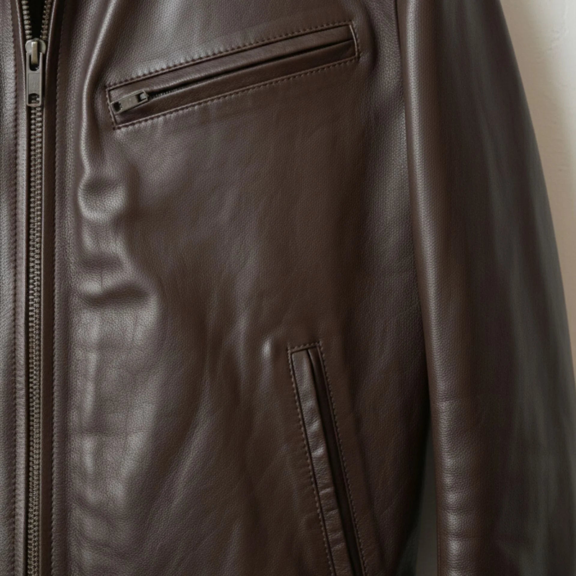 close up chest zipper pocket on mens brown bomber leather jacket.