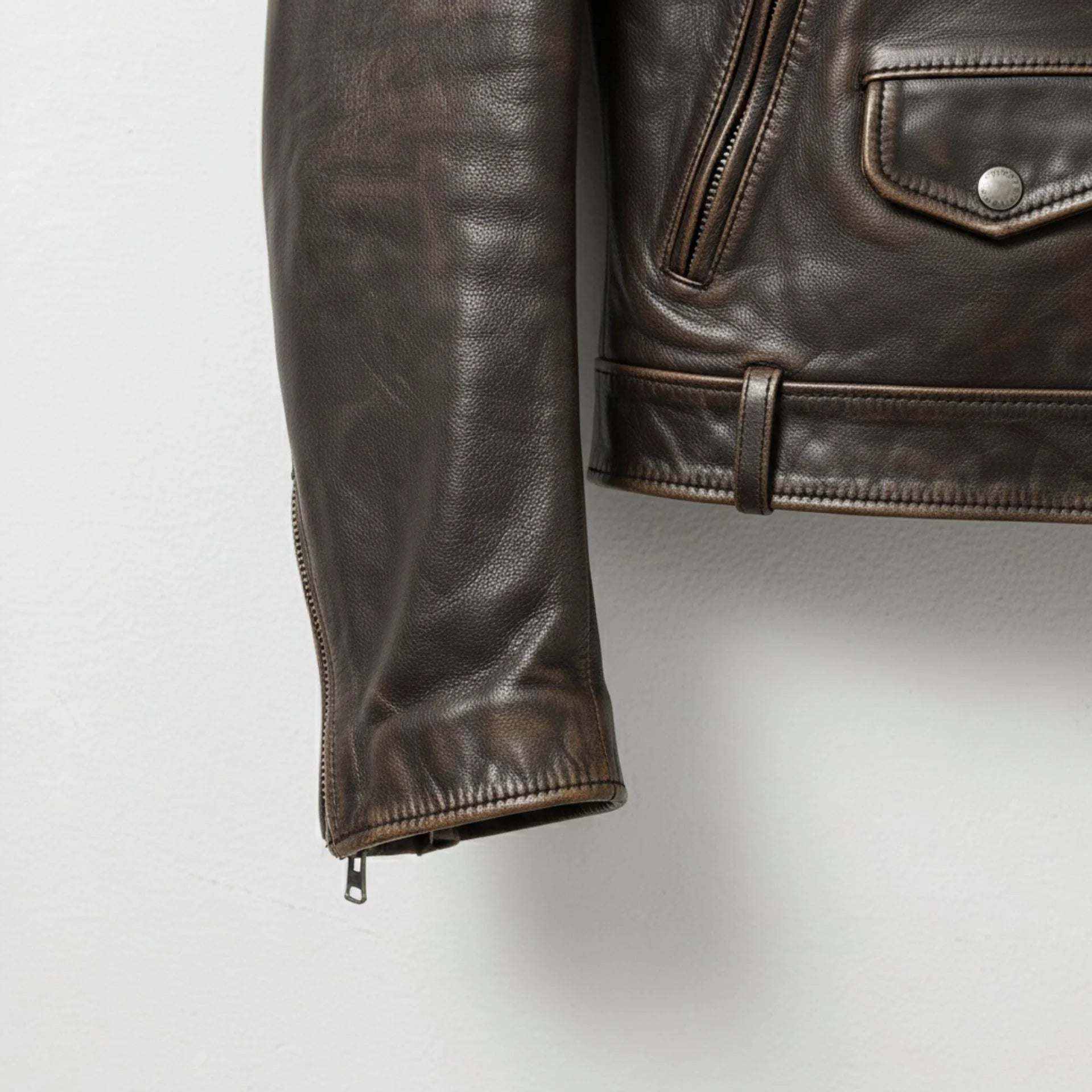 close up sleeve zipper cuff on mens brown cowhide biker jacket.