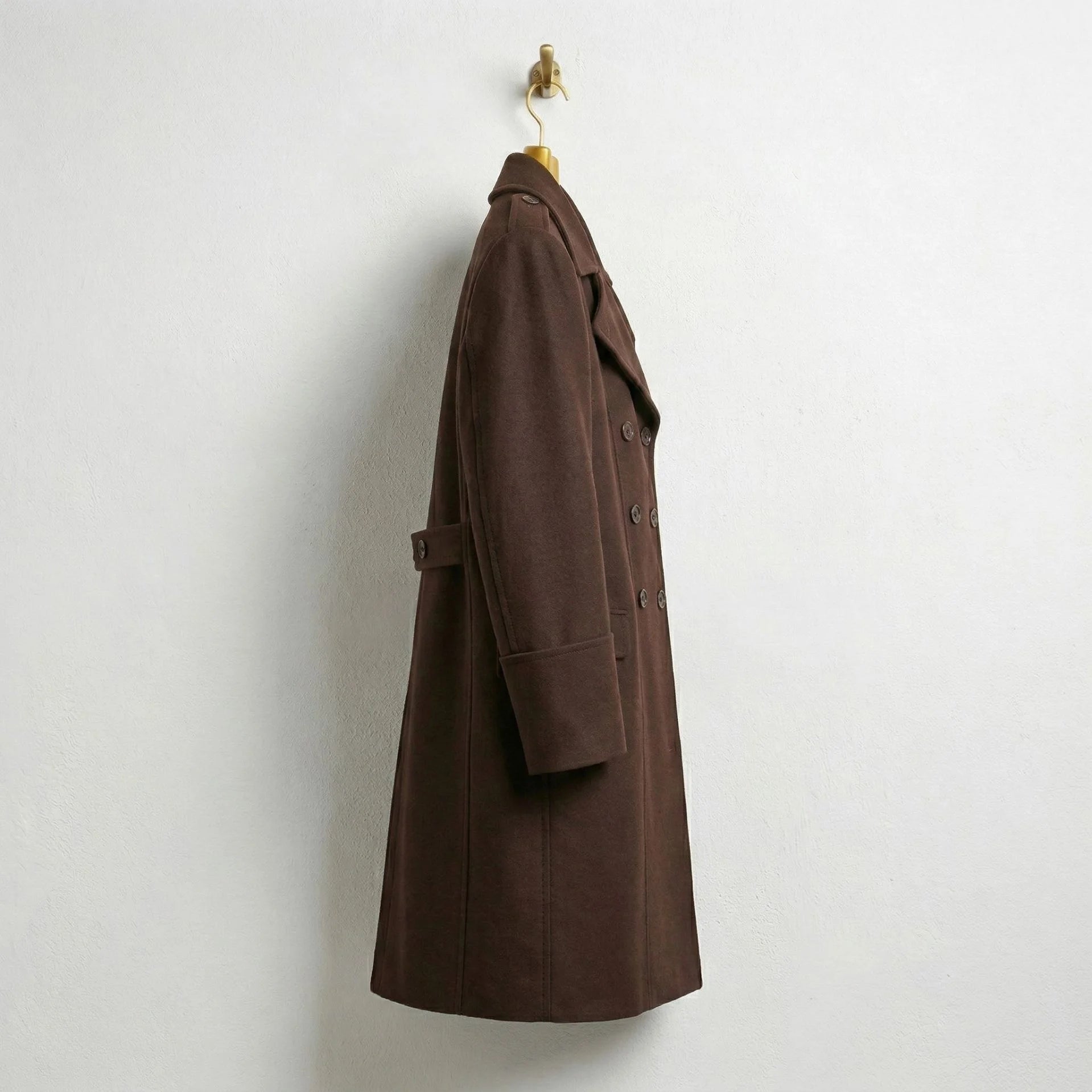 Side profile of men's long brown double breasted wool coat.