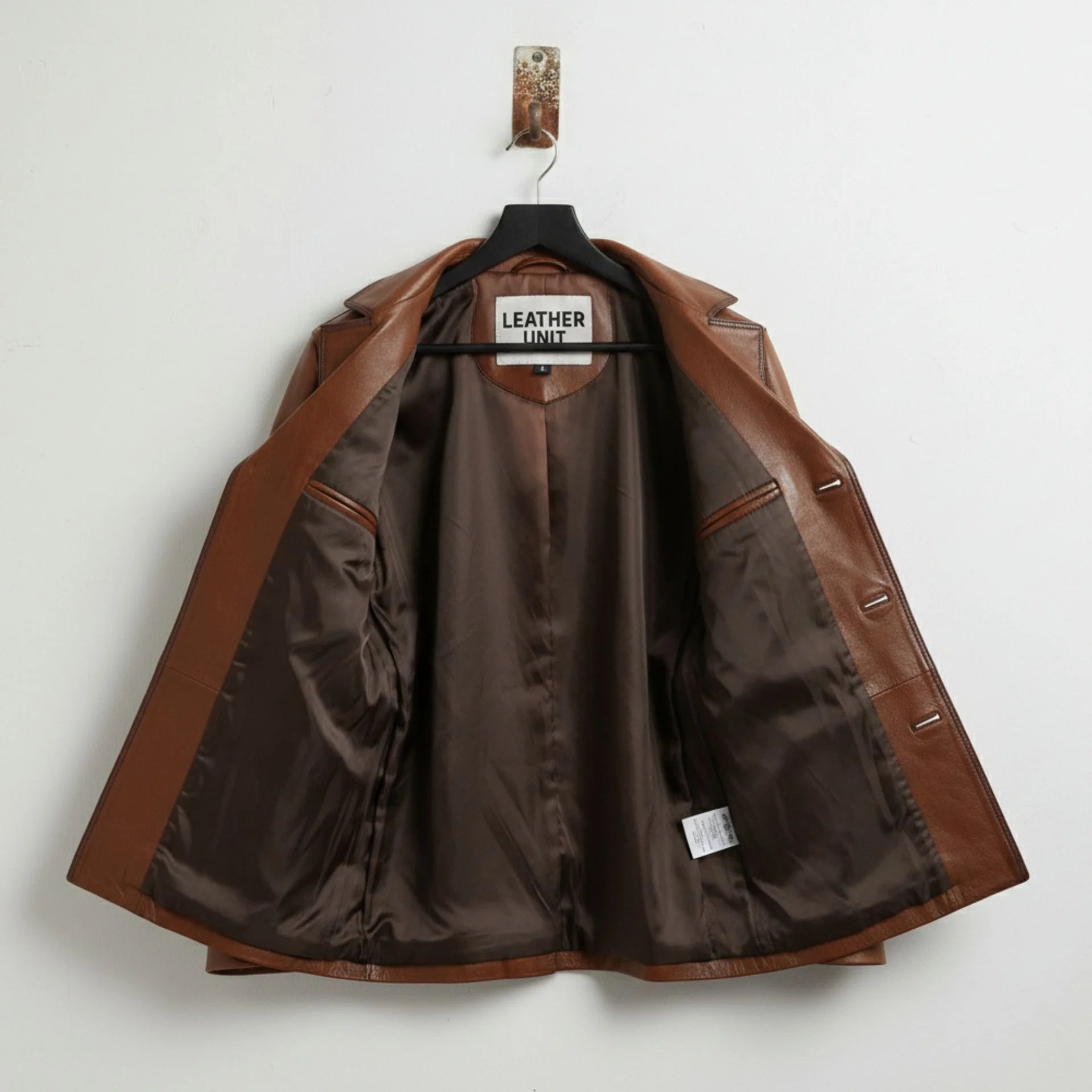 inside of men's brown leather blazer jacket showing satin lining and inner pockets.