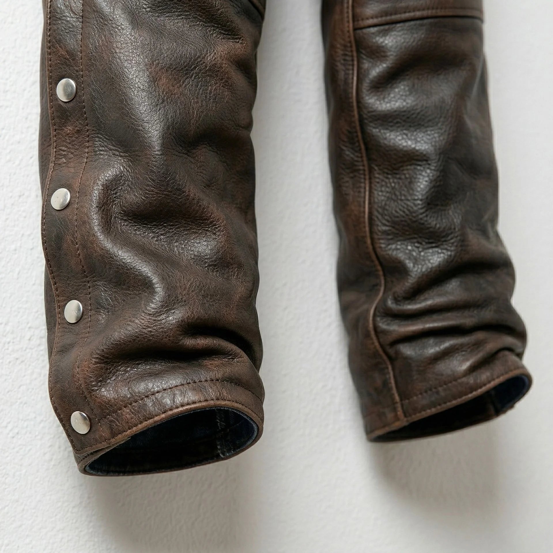 Detail of lower legs and snap closures on distressed brown leather chaps