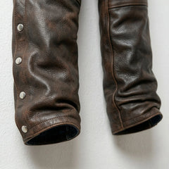 Detail of lower legs and snap closures on distressed brown leather chaps