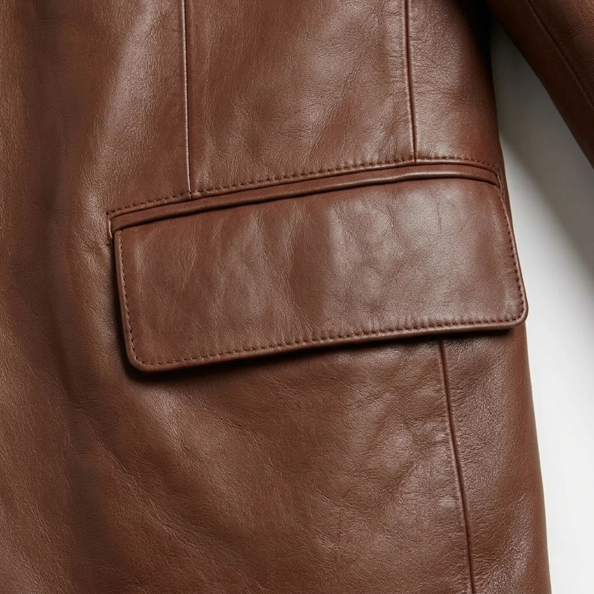 Flap pocket close up on men’s brown genuine leather blazer jacket