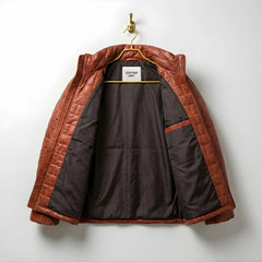 Inside view of men's brown leather puffer coat showing dark lining and inner pocket.