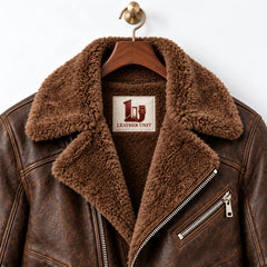 Close-up of faux fur collar and branded inner neck patch on espresso brown sheepskin leather aviator jacket