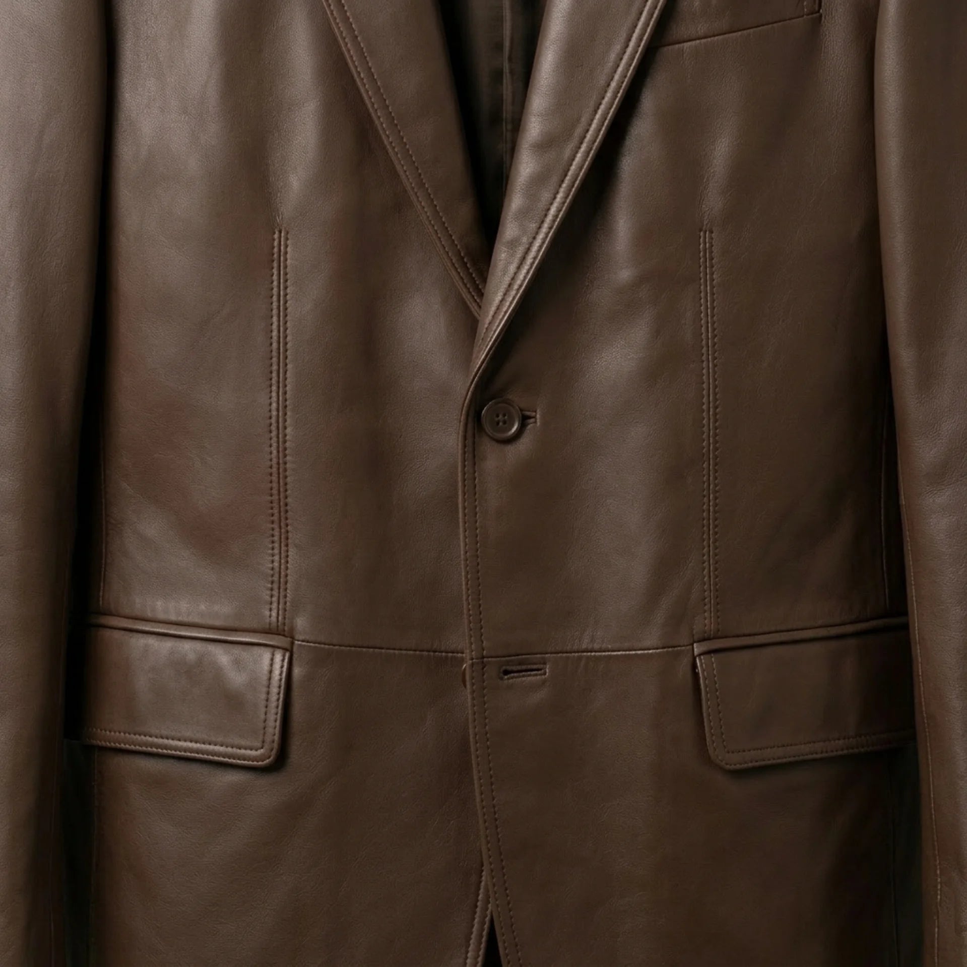 Button and flap pocket close up on men’s brown leather blazer jacket