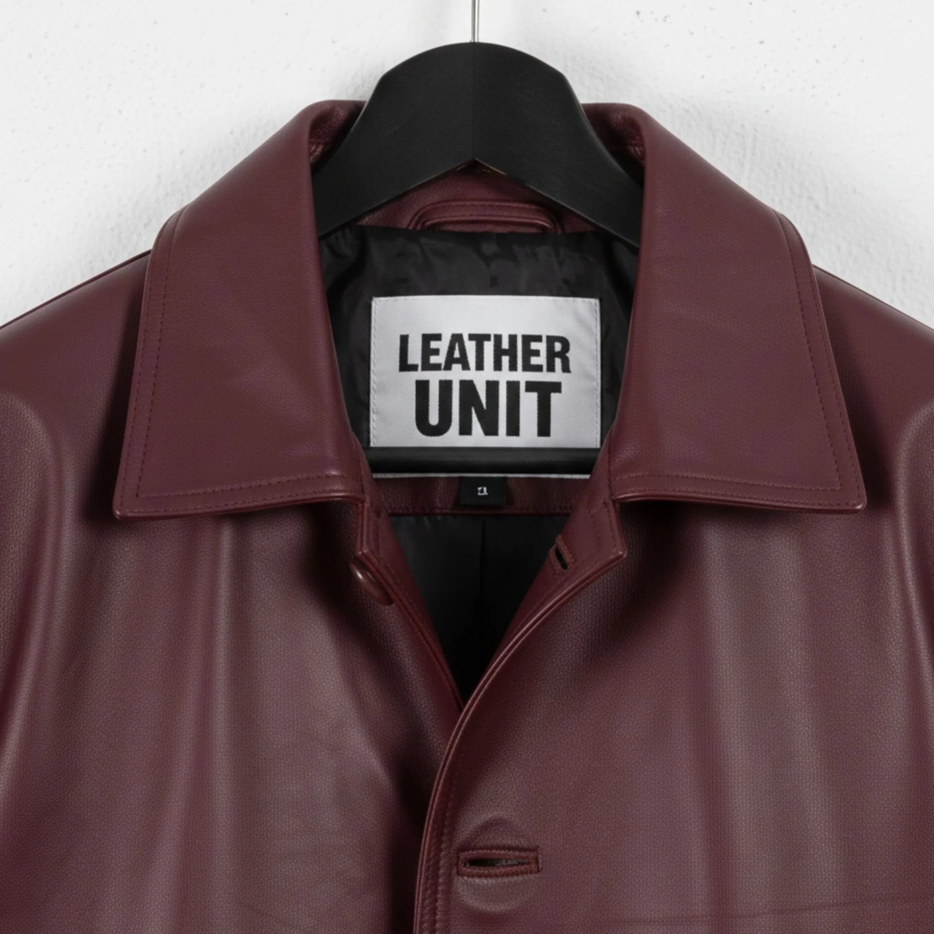 Close up of collar and Leather Unit label on burgundy leather coat