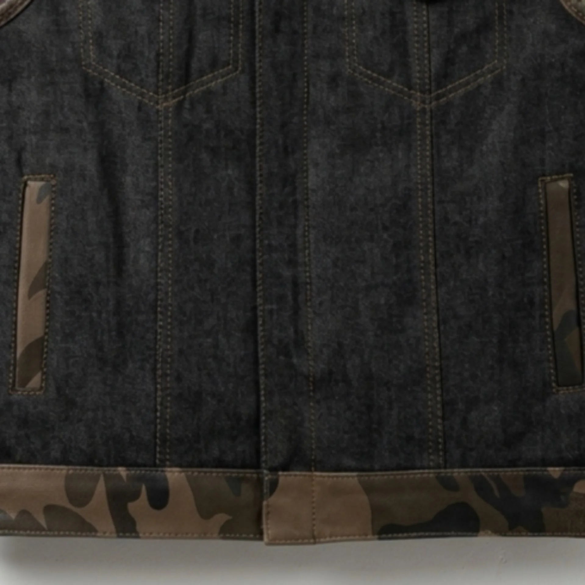 Close-up of denim body, camo hem and hand pockets on men's camo biker vest