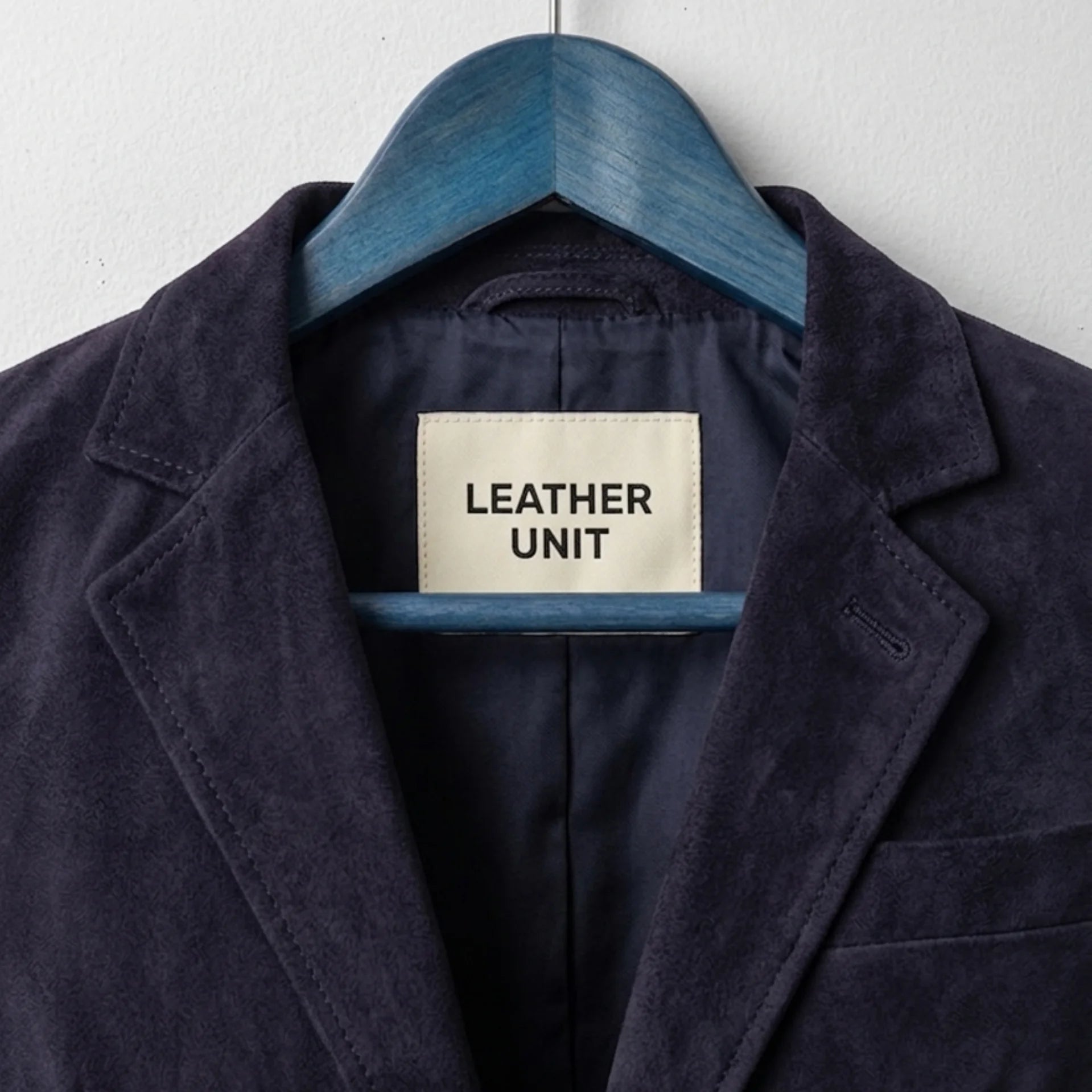 Close up of notch lapel and Leather Unit label on purple suede blazer