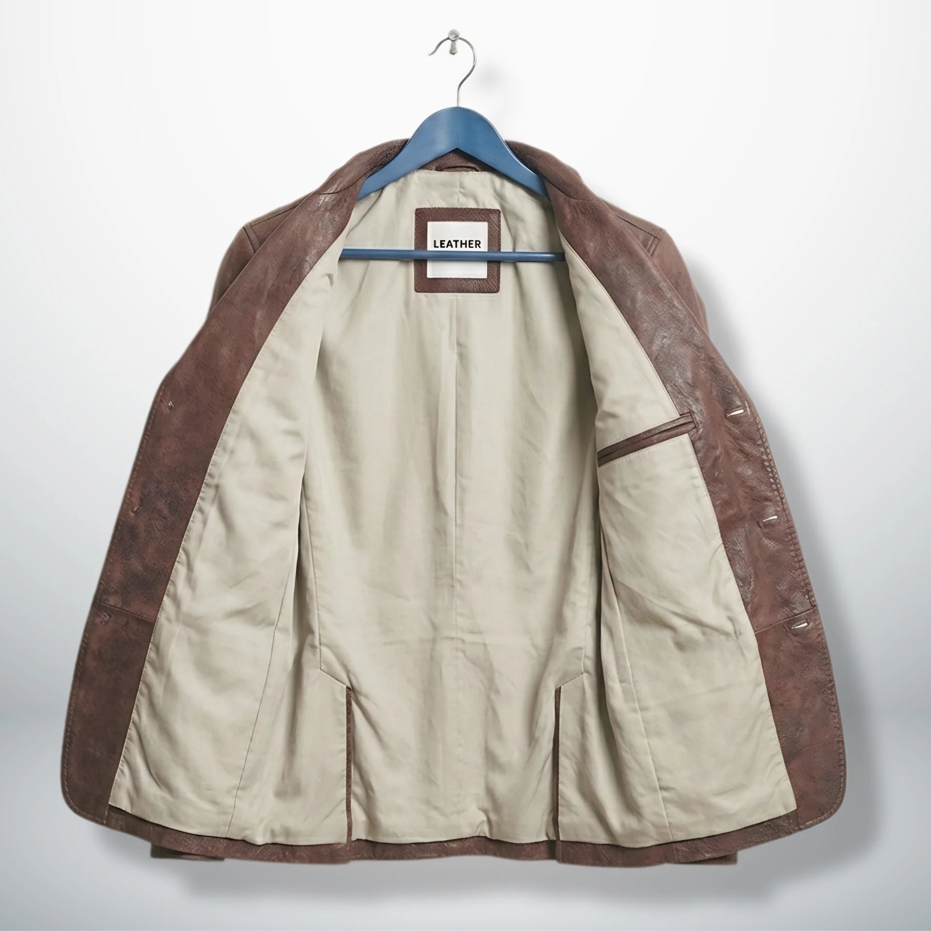 Inside beige lining of men’s distressed brown leather blazer jacket
