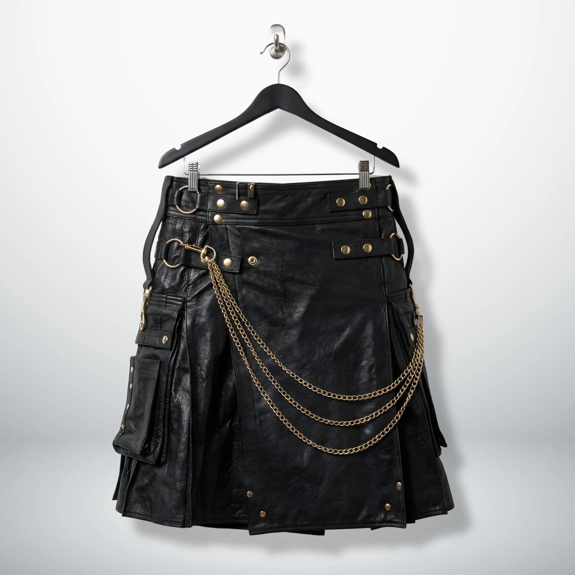 Front view of men's black gothic leather utility kilt with gold chains and pockets