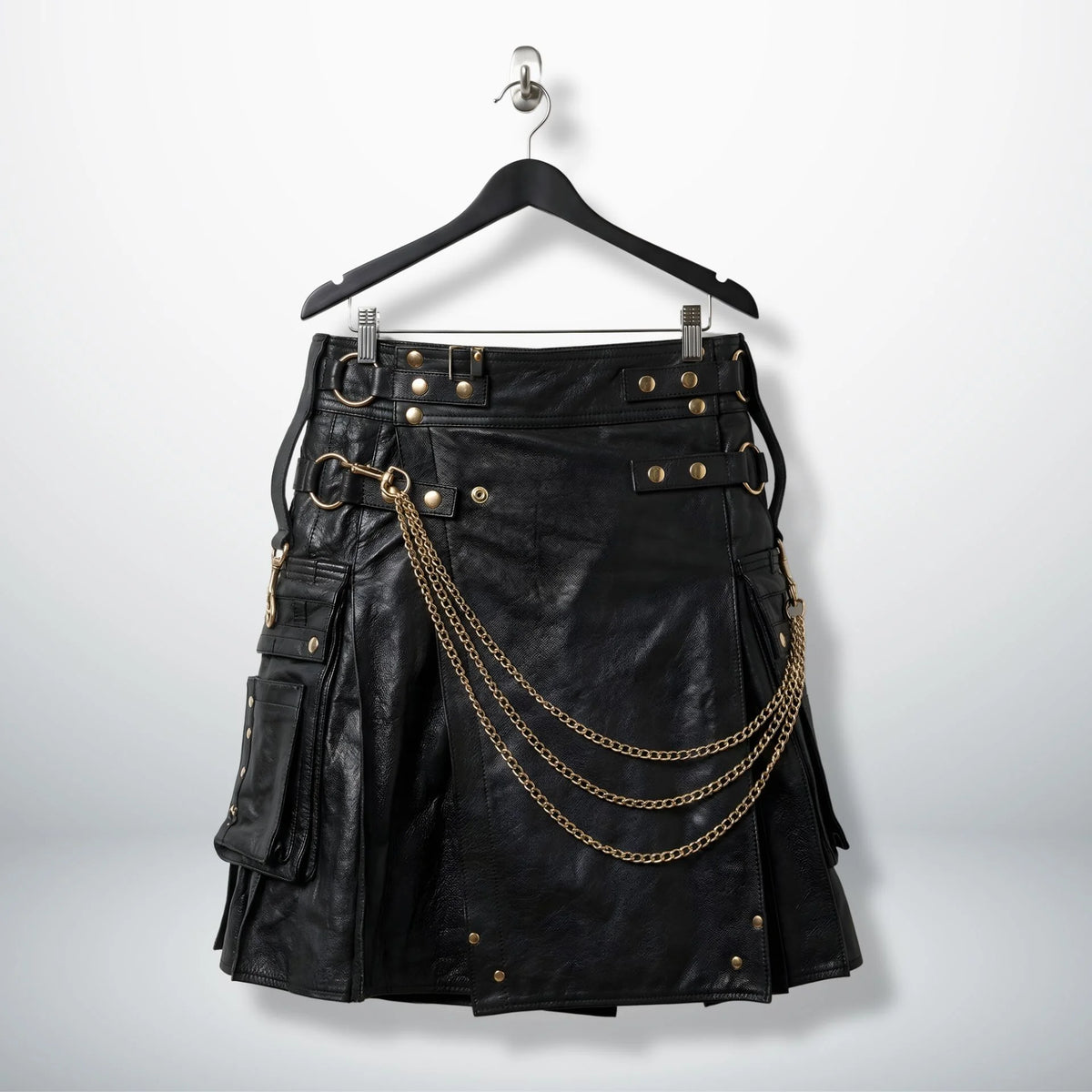 Front view of men's black gothic leather utility kilt with gold chains and pockets