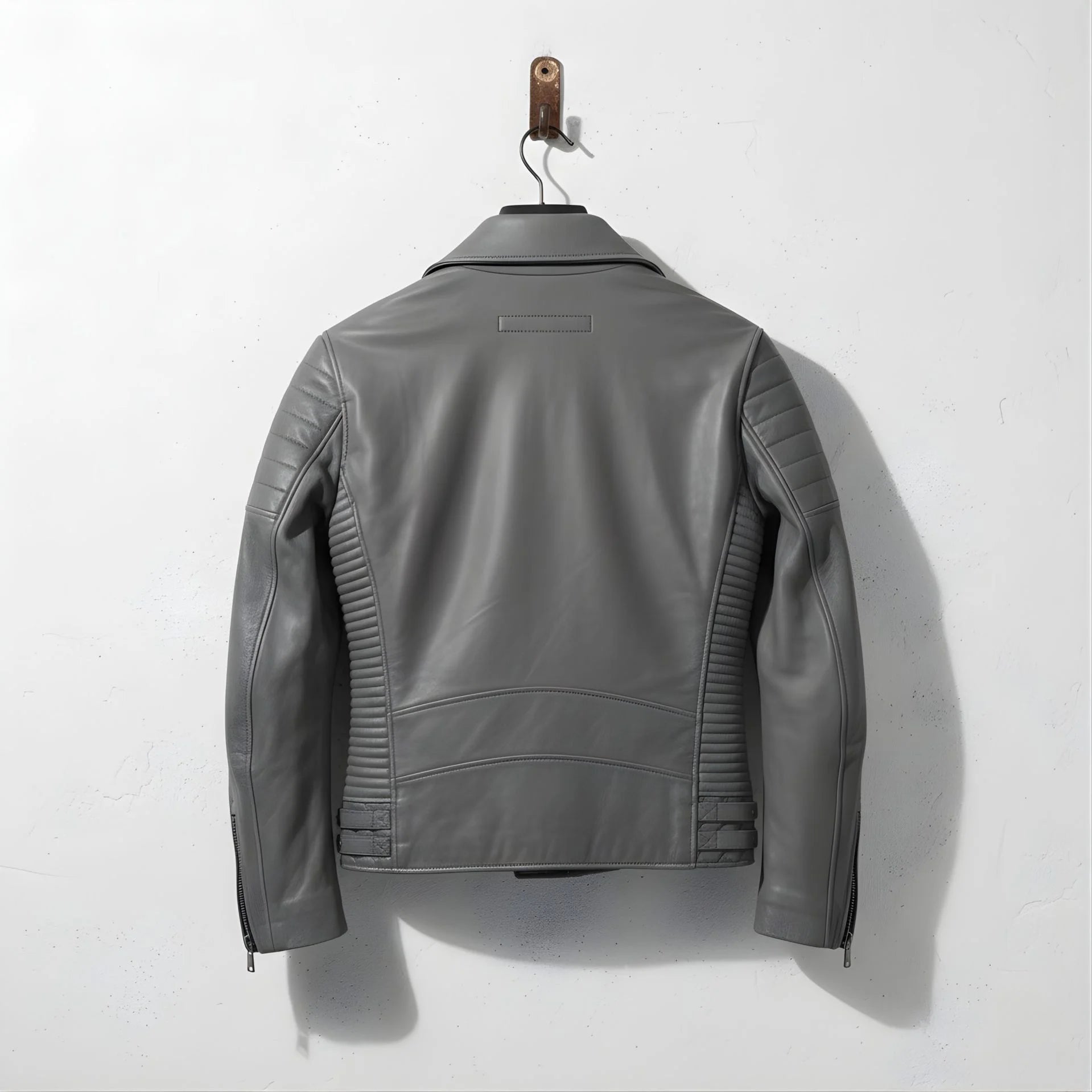 back view of men's grey leather moto jacket with ribbed side panels.