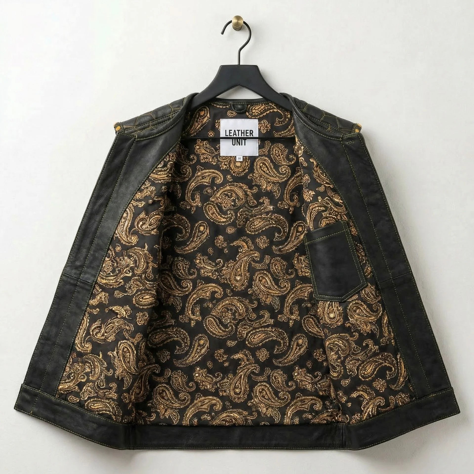 Inside of men's leather biker vest showing black and gold paisley lining and pocket