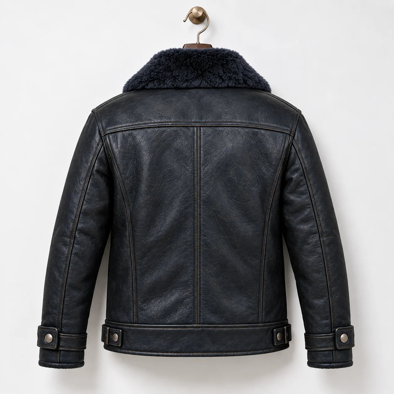 Back hanger view of navy leather flight jacket showing natural grain, panel seams and adjustable hem tabs