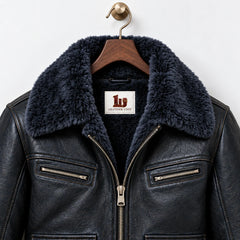 Close-up of midnight navy faux fur collar, natural grain sheepskin leather and zipped chest pockets