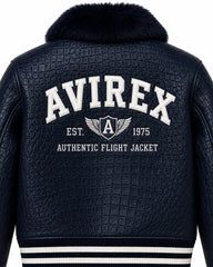 Close-up back of navy croc-textured leather bomber with large white aviation lettering, wing crest and fur collar