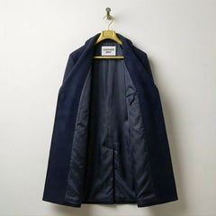 Interior of men's navy wool overcoat showing smooth lining and inner pocket.