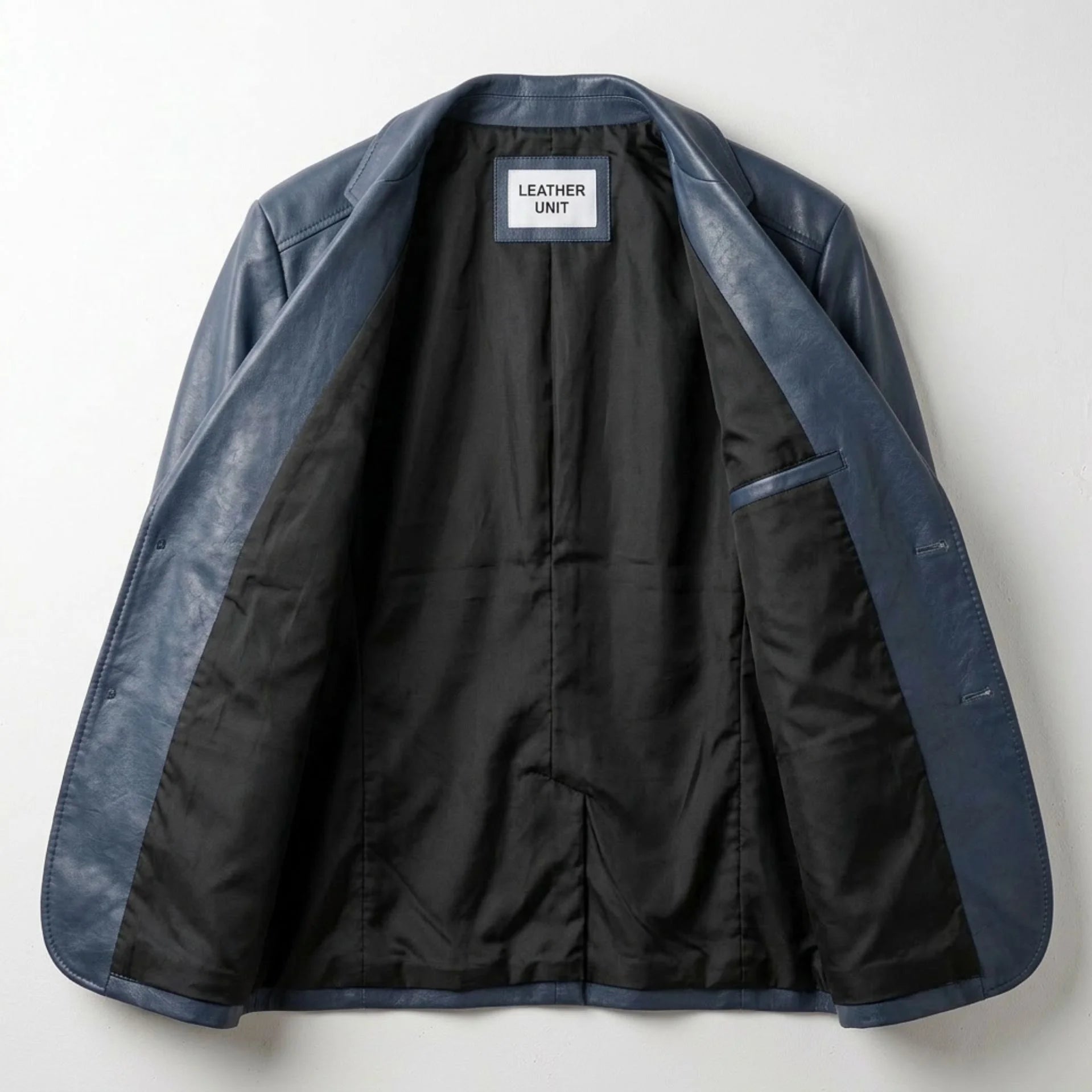 Interior of men's navy leather blazer showing black lining and inner pocket.