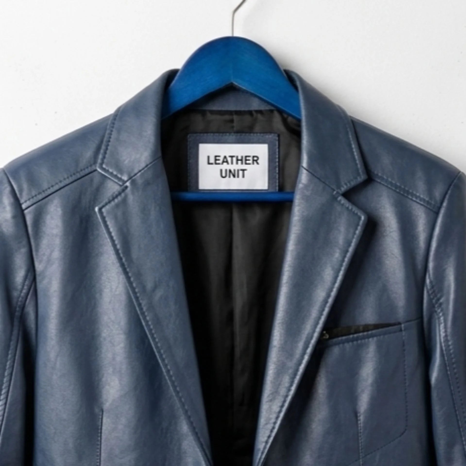 Close up of lapel collar and Leather Unit label on navy leather blazer.