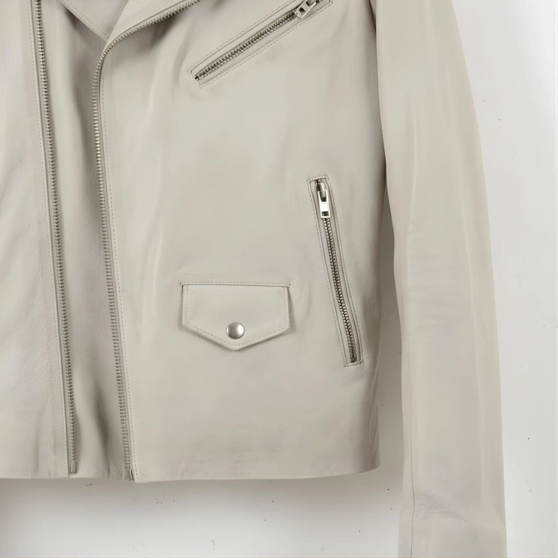 detail of pockets and front zip on men's off white leather motorcycle jacket.