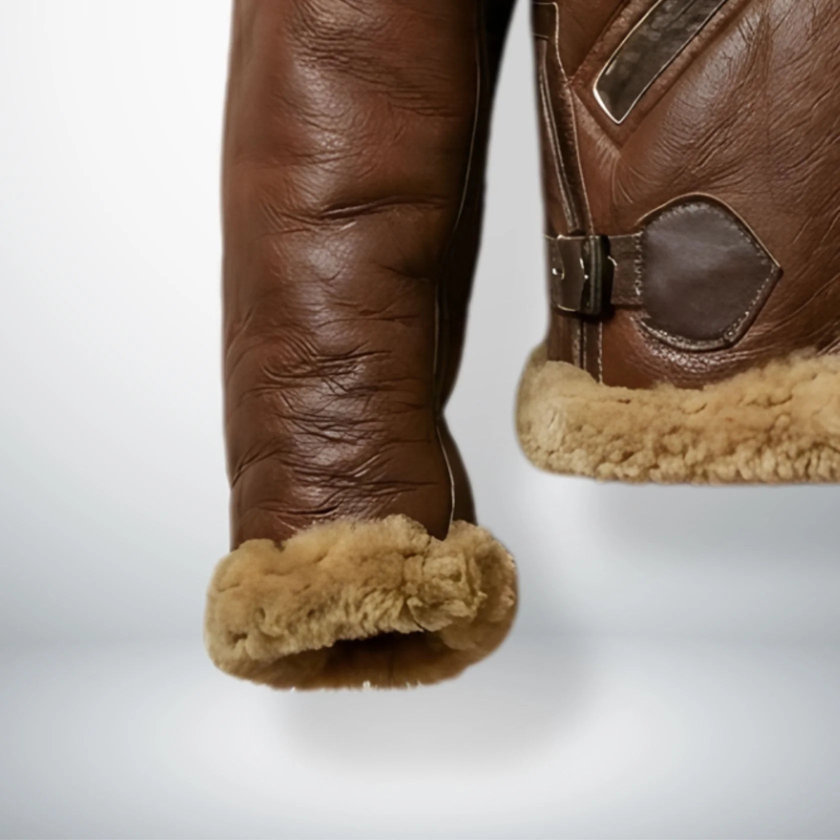 close up shearling cuff and side waist buckle on mens brown pilot jacket.