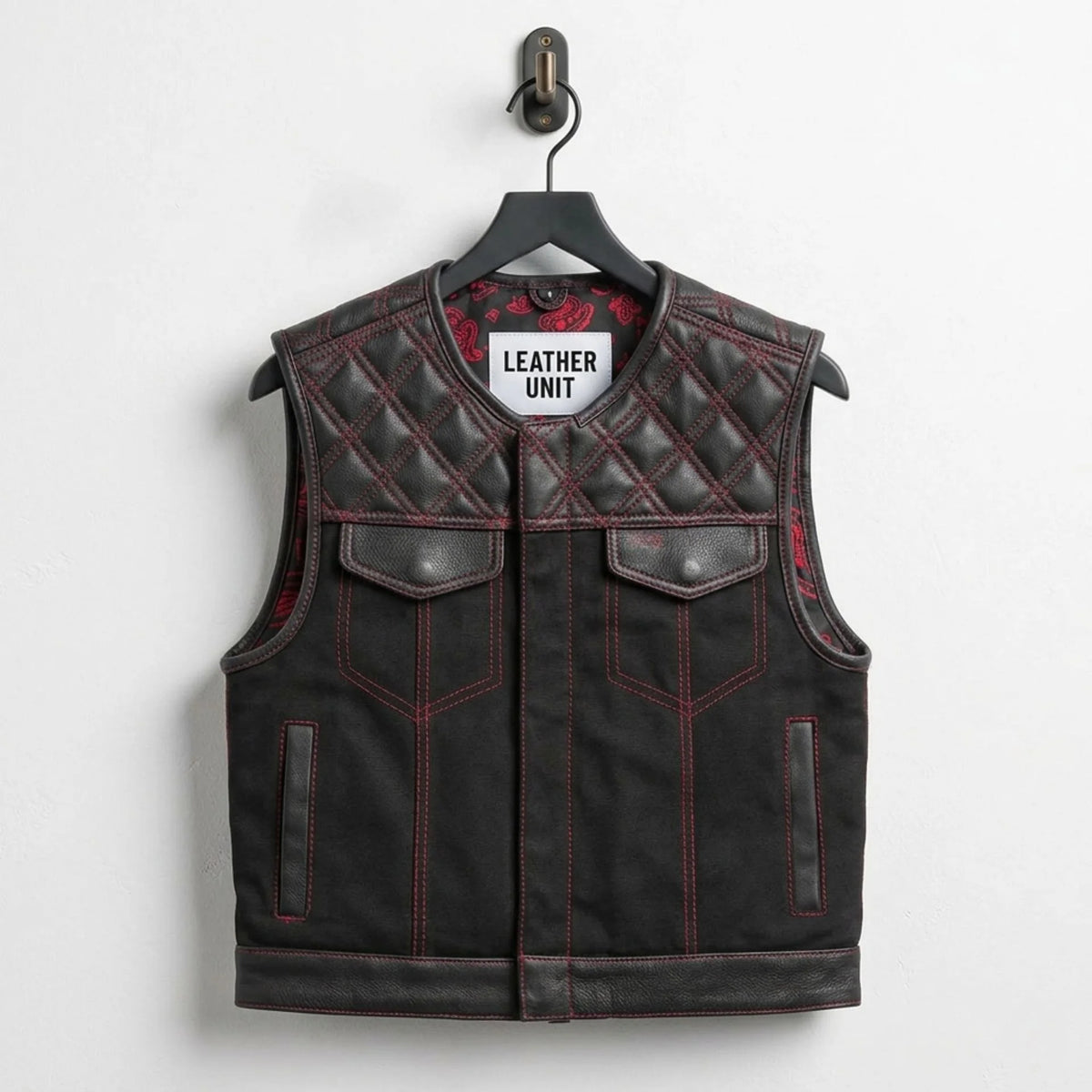 Front view of men's black quilted leather biker vest with red stitching by Leather Unit