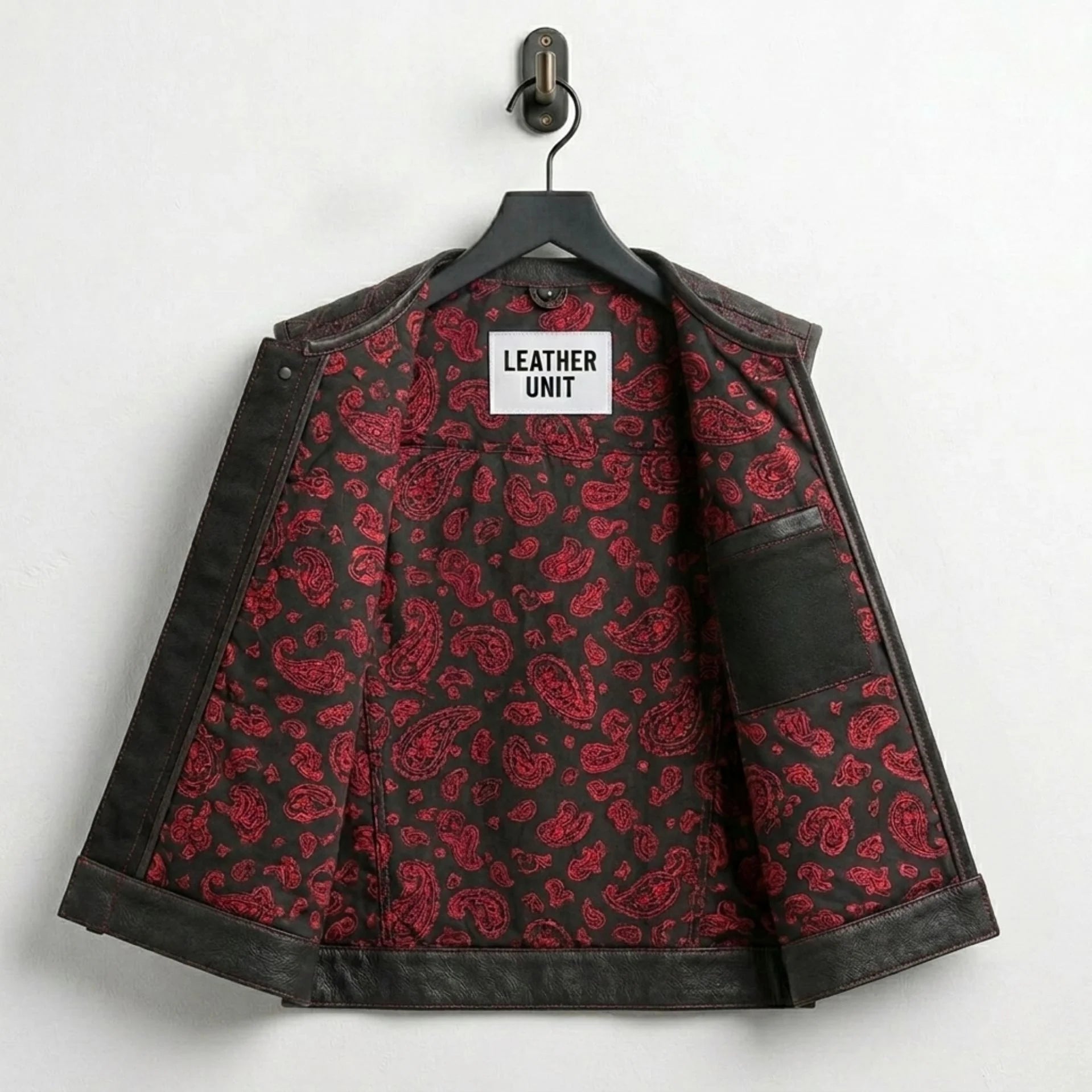 Interior of men's leather biker vest showing red paisley lining and inside pocket