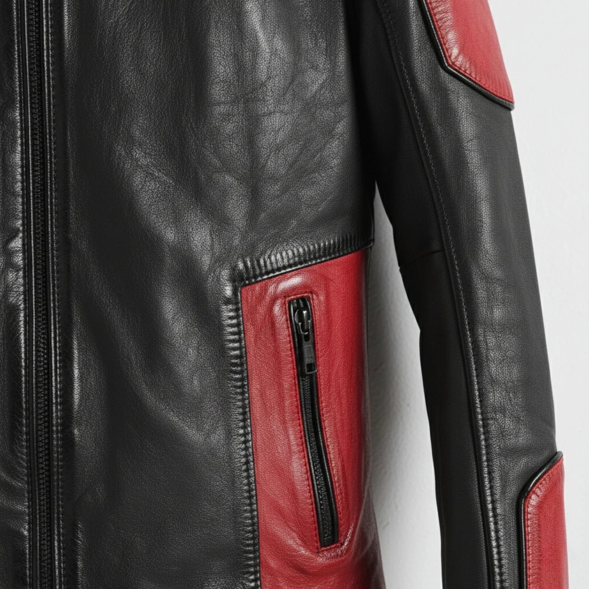 detail of red pocket panel and zipper on men's black leather biker jacket.