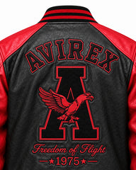 Close-up of black leather varsity jacket back with red embroidered lettering, eagle graphic and red shoulder panels